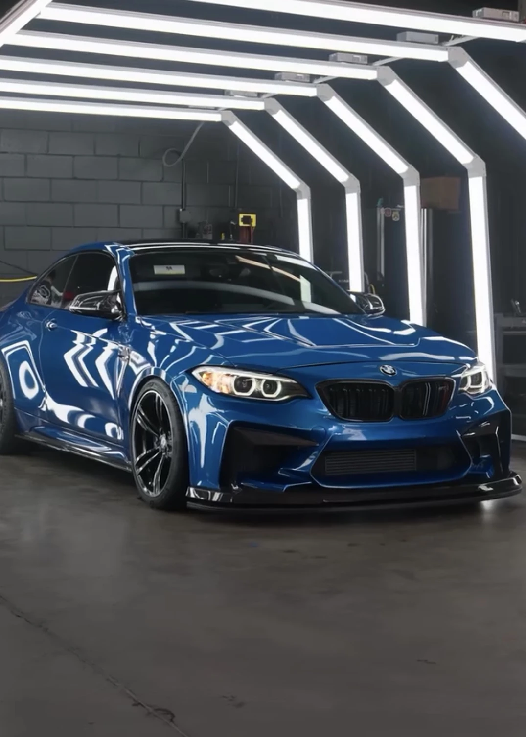 Blue BMW with a glossy finish under the detailing studio lights