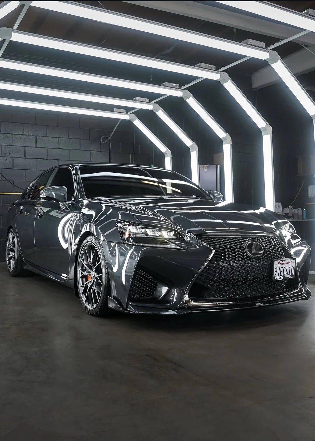 Gray Lexus with a glossy finish under the detailing studio lights